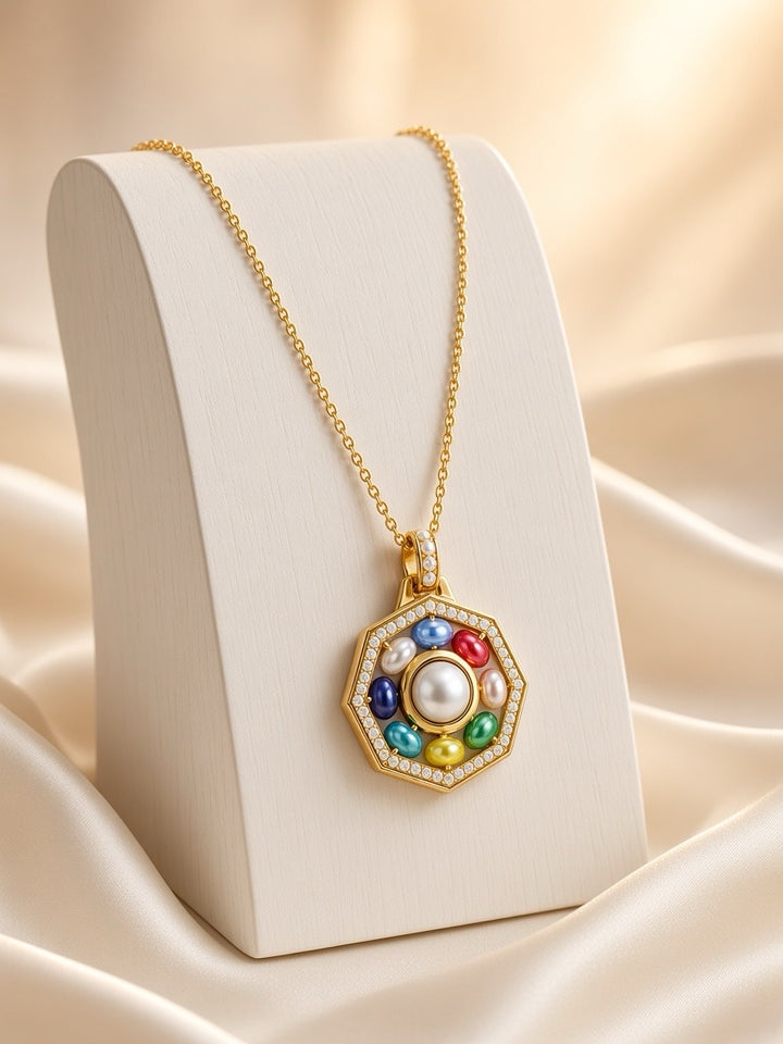 ORA Necklace — octagonal gold-tone pendant with coloured glass beads around a central shell pearl, on a display stand